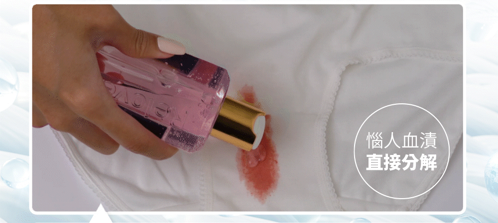 一隻手將粉紅色瓶子裡的液體倒在白色衣服上的紅色污漬上。文字寫著「去污」。