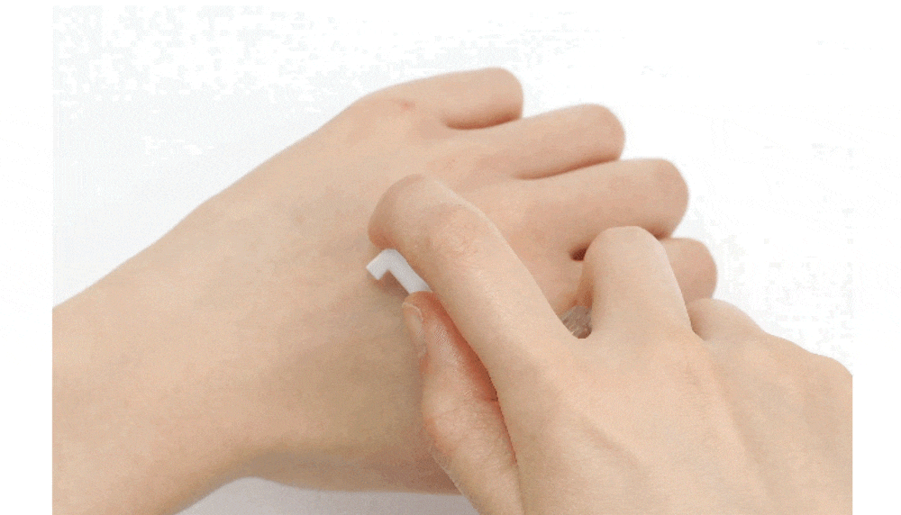 一個人在白色背景下用小塗抹器將乳霜塗抹在手上。