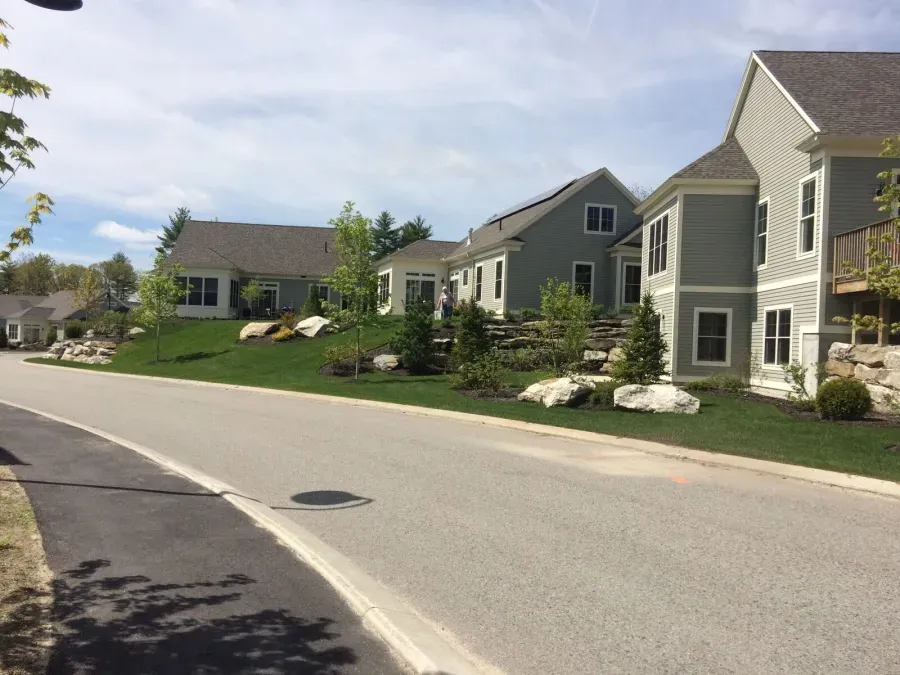 A row of houses are lined up on the side of a road
