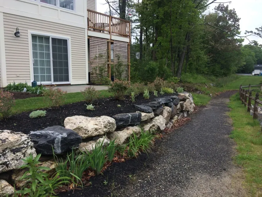 A house with a stone wall in front of it