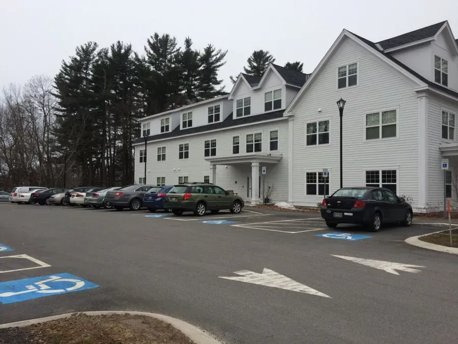 A large white building with cars parked in front of it