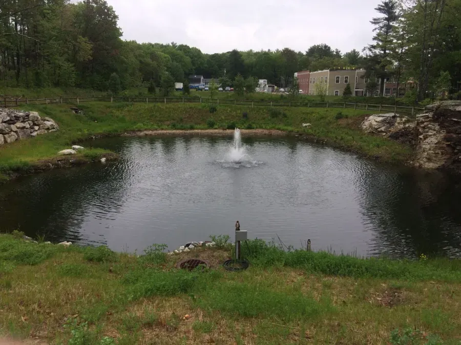 A pond with a fountain in the middle of it