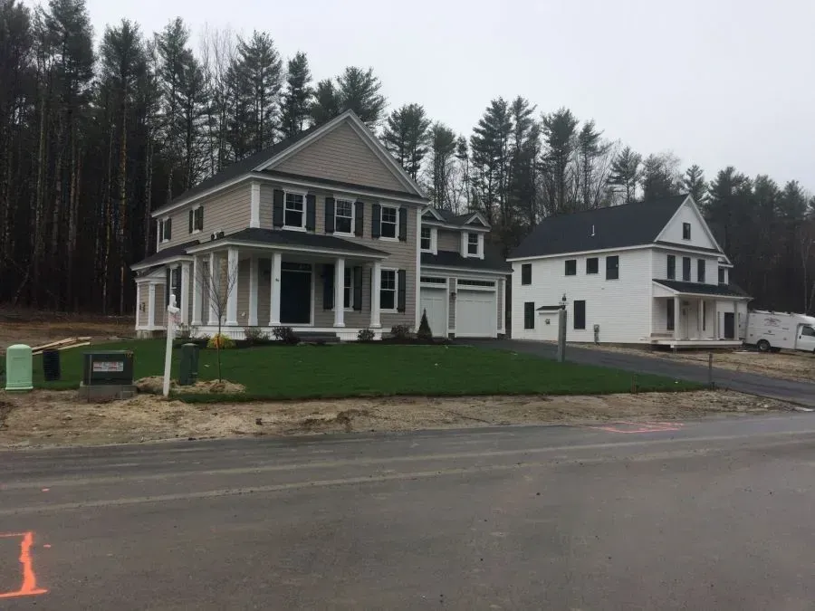 A couple of houses are sitting next to each other on the side of a road.