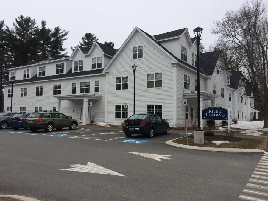 A large white building with cars parked in front of it