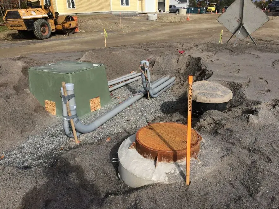 A manhole cover is sitting in the middle of a dirt field.