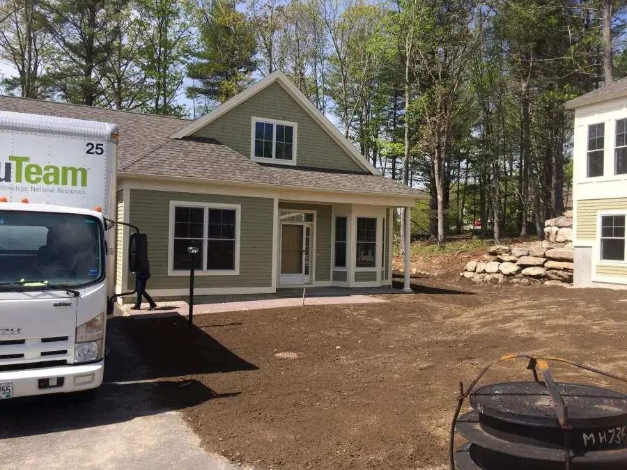 A white truck with the word team on it is parked in front of a house