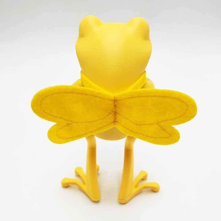 Yellow and brown frog-bee hybrid figurine with large eyes, wings, and striped torso, standing upright.