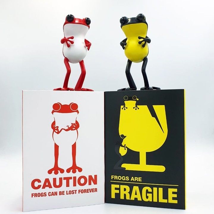Two frog figurines atop signs: 