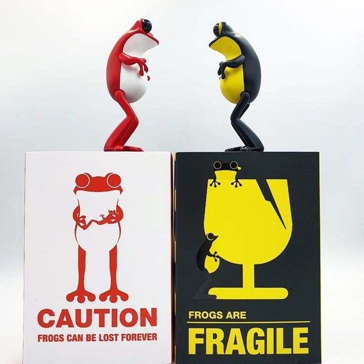 Two frog figurines atop signs: 