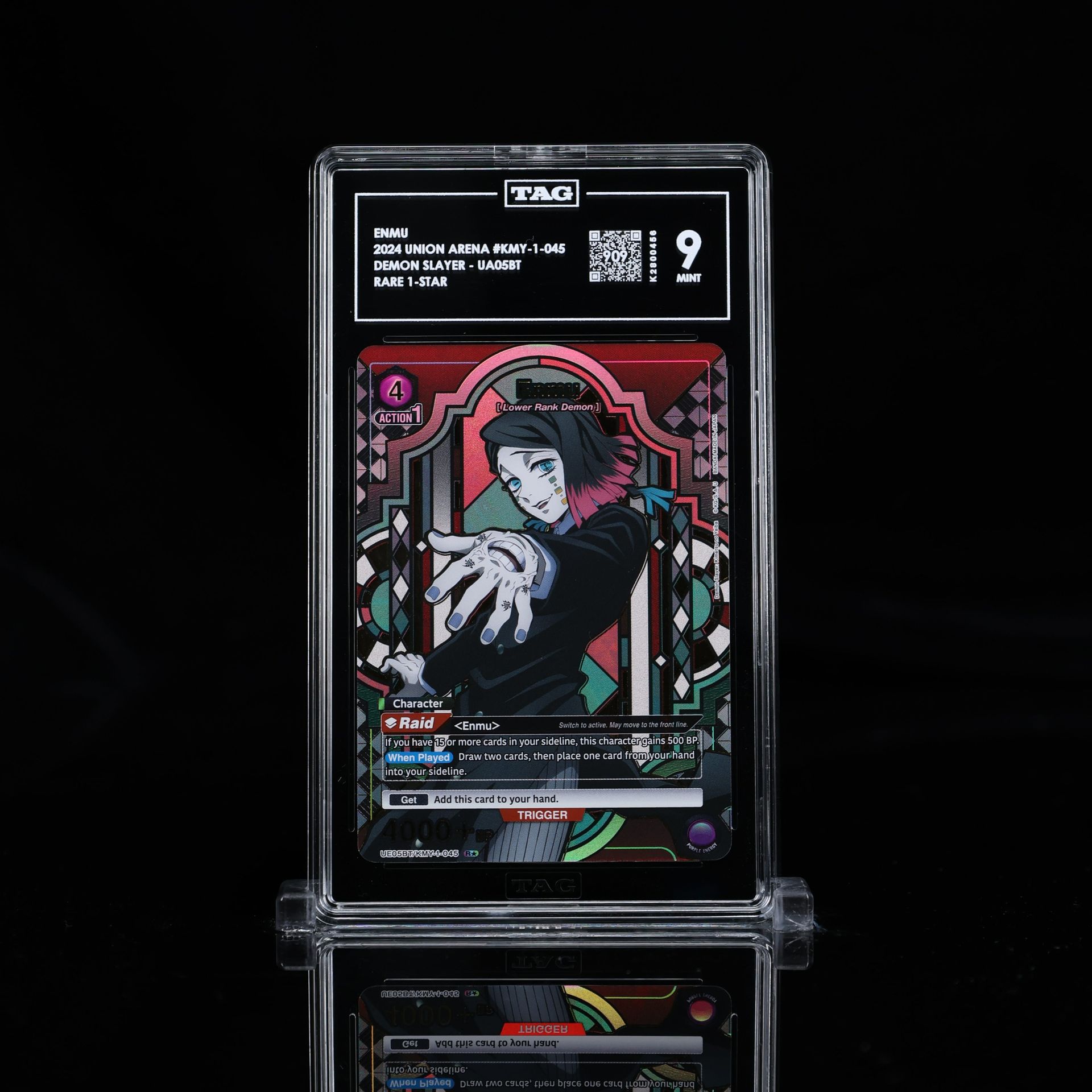 Graded Demon Slayer card in a case. The card shows a character with a pointing hand, set against a colorful background.