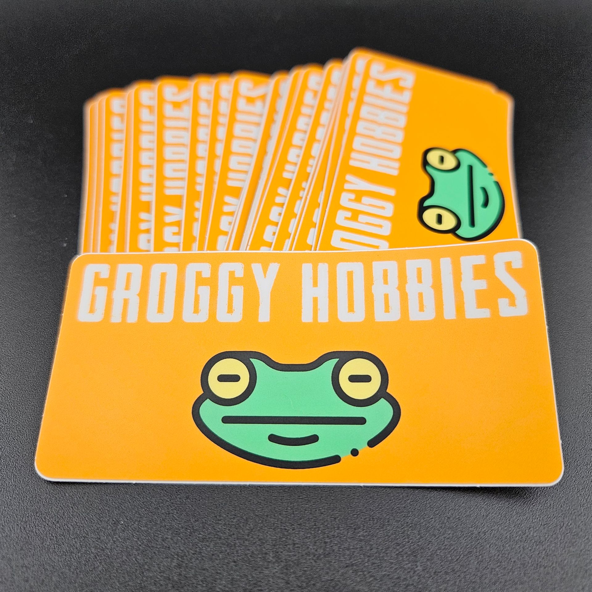 Stack of Grogggy Hobbies cards with a frog graphic on an orange background.