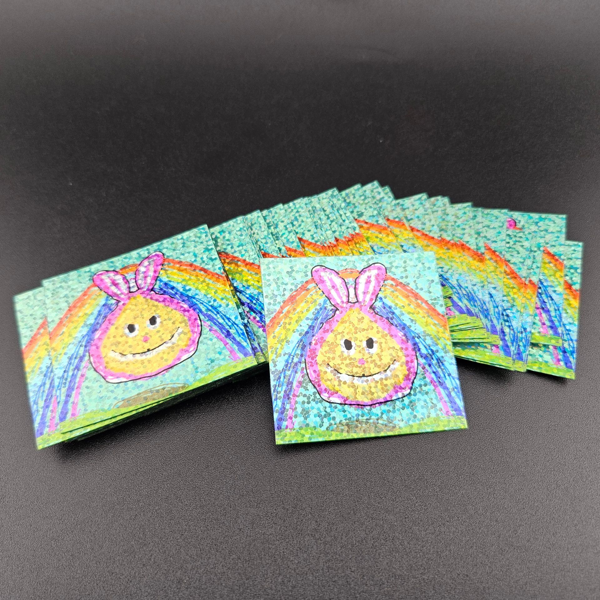 Square stickers with a cartoon bunny and rainbow.