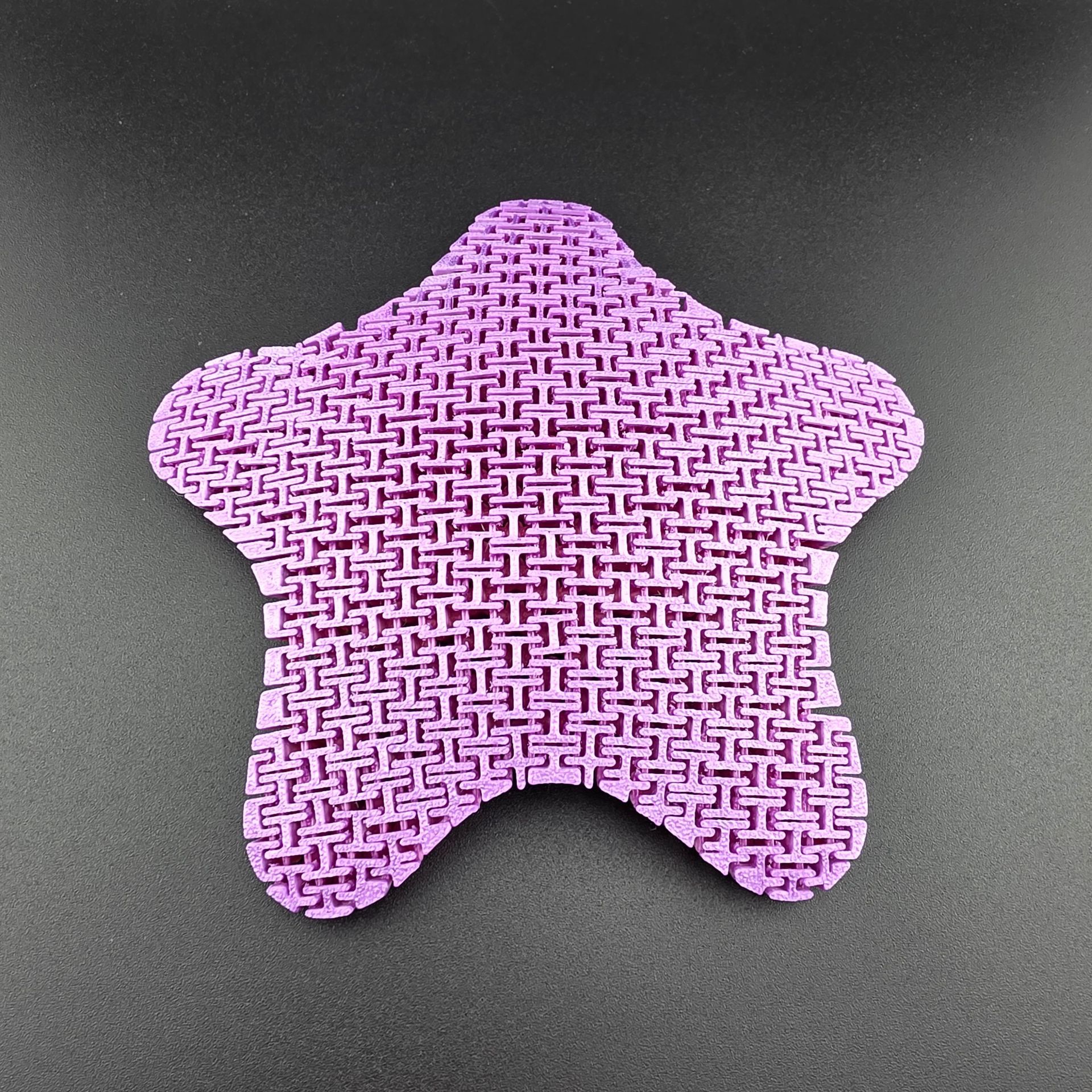 Three colorful, rainbow-hued starfish toys on a dark surface.