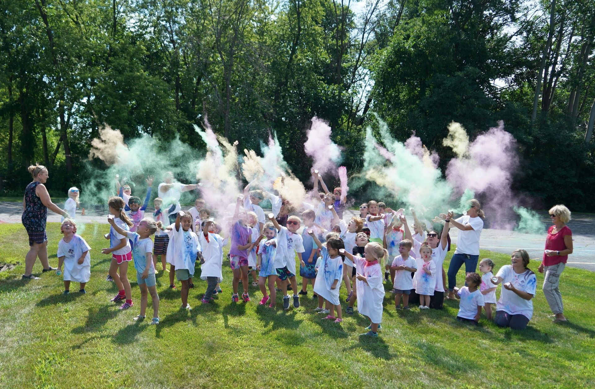 A group of children are throwing colored powder in the air