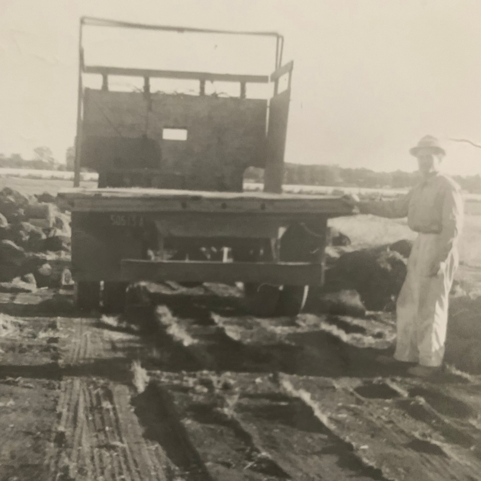 Romeo Alfano standing next to his truck A black and white photo of a man standing in front of a truck