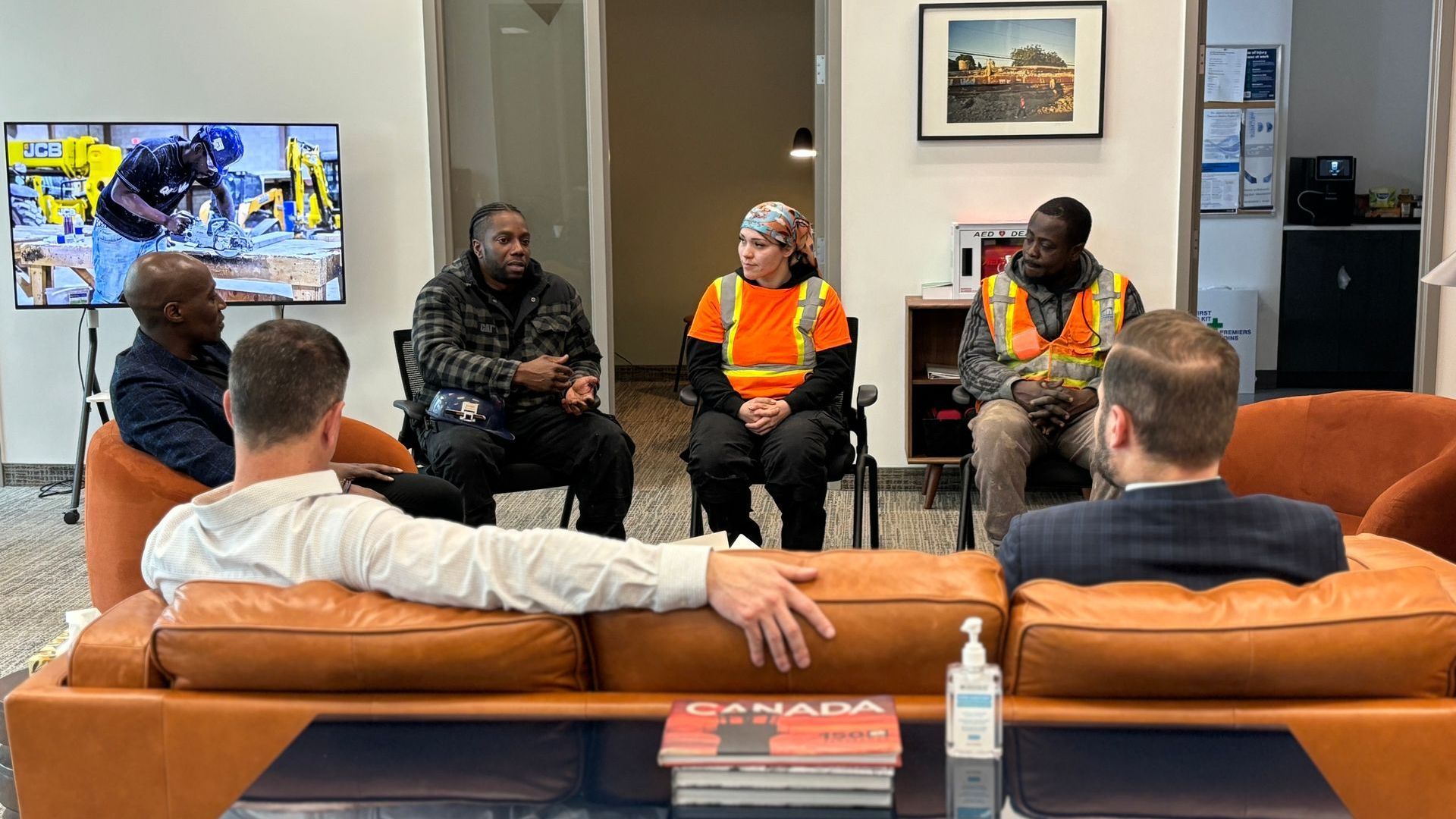 A group of people are sitting around a couch.