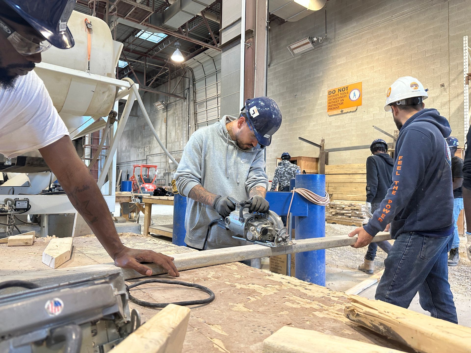 A man is using a circular saw to cut a piece of wood.