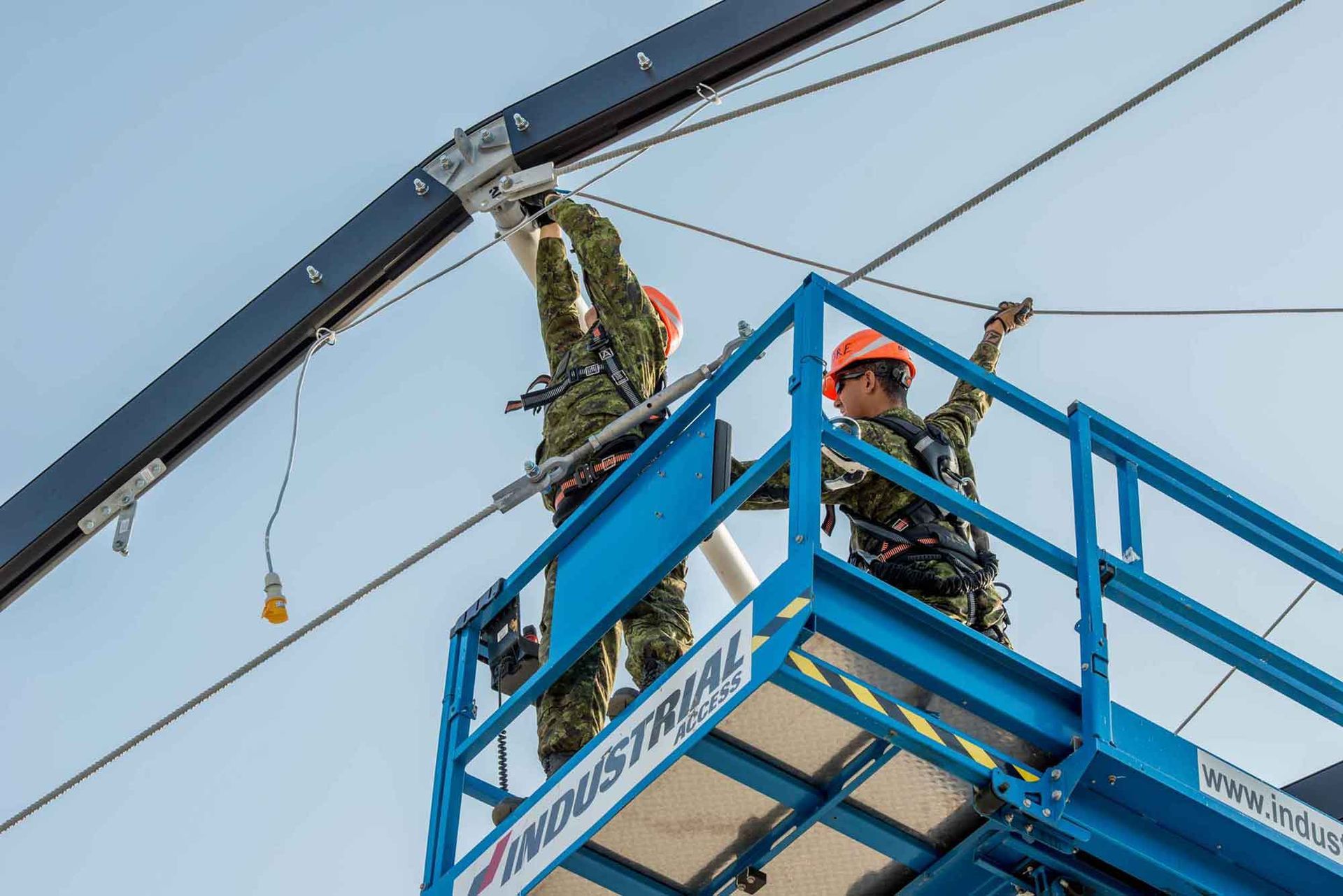 A couple of men are working on a crane.