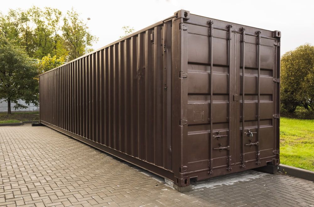 A Large Brown Shipping Container is Parked in a Parking Lot — Mareeba Express Towing in Mareeba, QLD