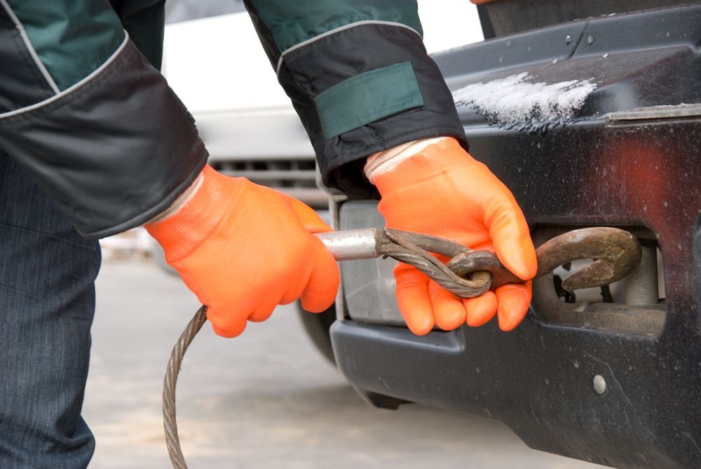 A Person Wearing Orange Gloves is Towing a Car — Mareeba Express Towing in Mareeba, QLD