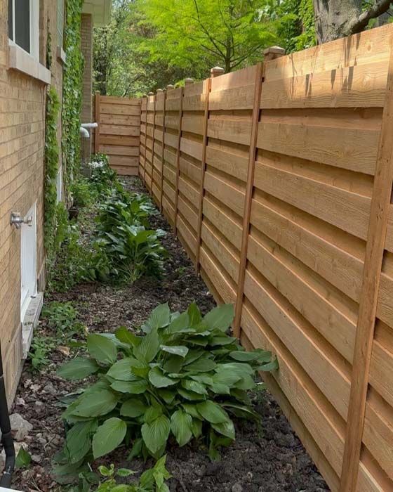 A wooden fence along the side of a house