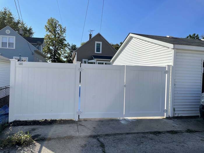 A white fence is sitting in front of a house.