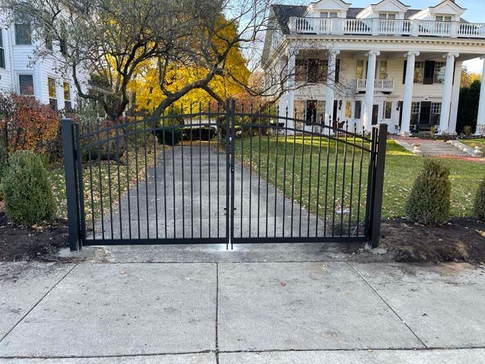 A large white house with a black gate in front of it.