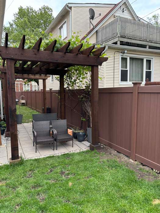 There is a pergola in the backyard of a house.