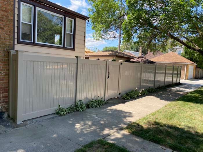 A white fence is sitting in front of a house.