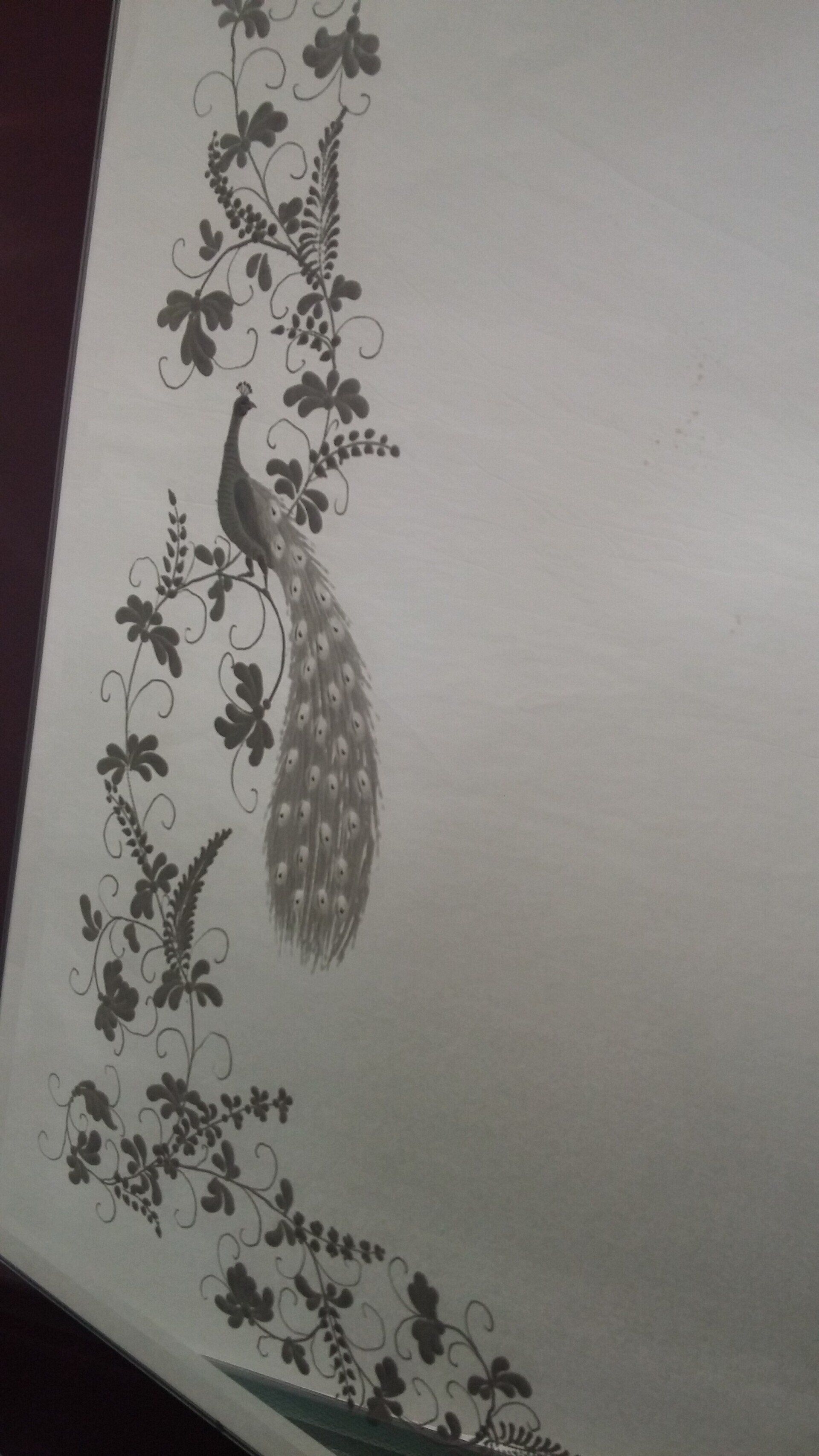 Illustrazione di pavoni e viticci su una superficie di colore chiaro, probabilmente un muro.