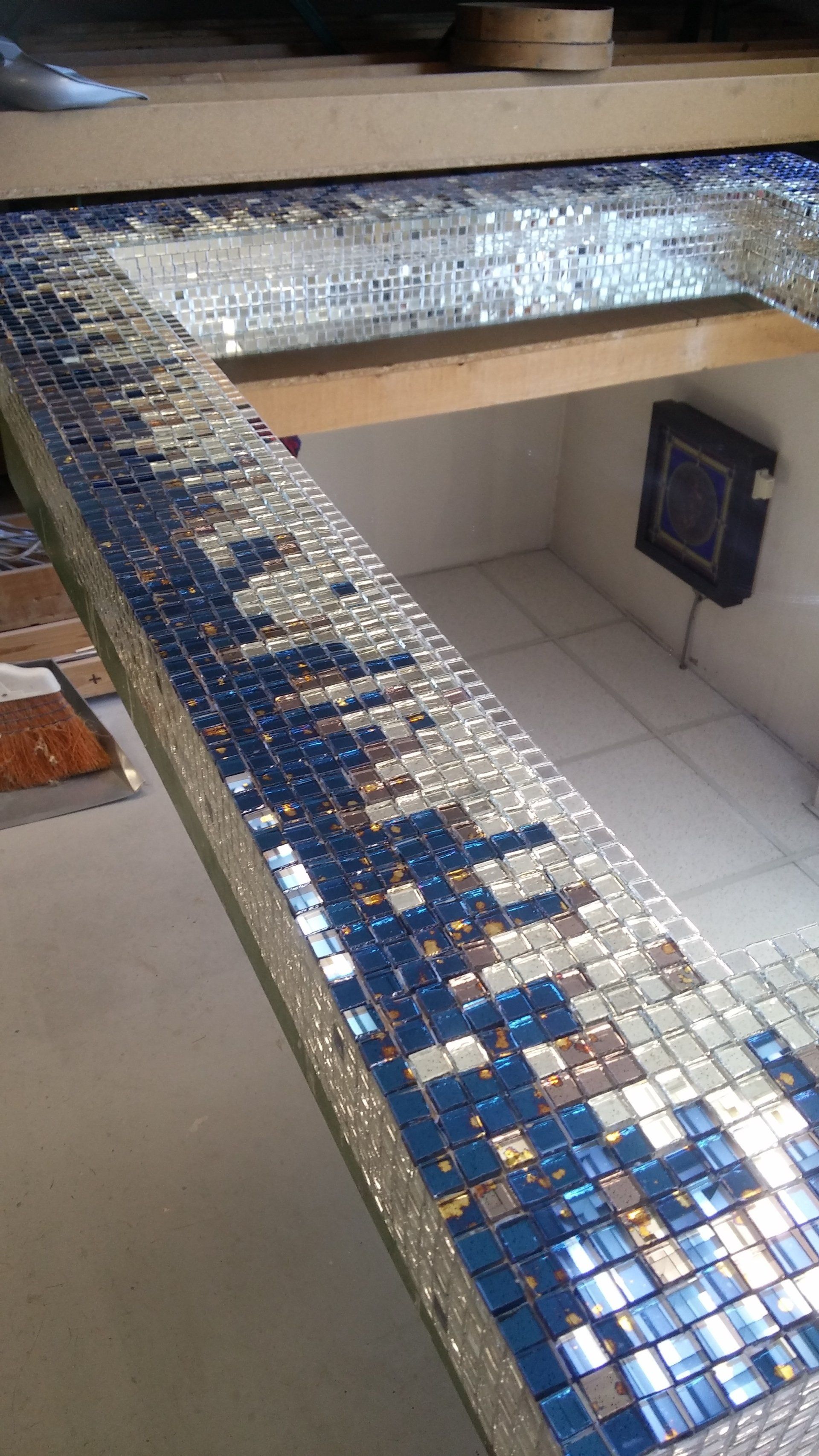 Piastrelle blu e specchiate installate sul bordo di una struttura; impostazione dello spazio di lavoro.