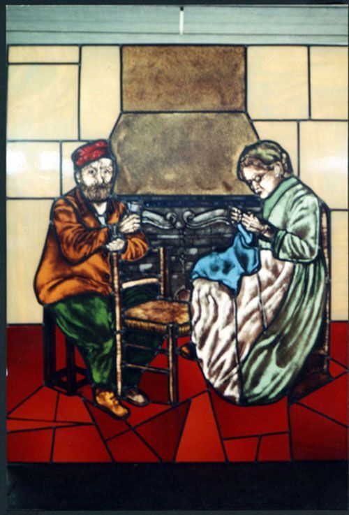 Vetrata raffigurante un uomo seduto con un bastone e una donna che lavora a maglia vicino a un camino, entrambi in abiti d'epoca.