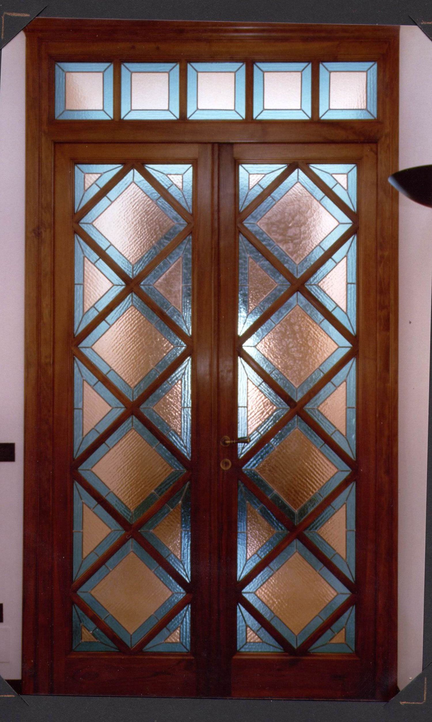 Doppie porte in legno con vetri colorati.