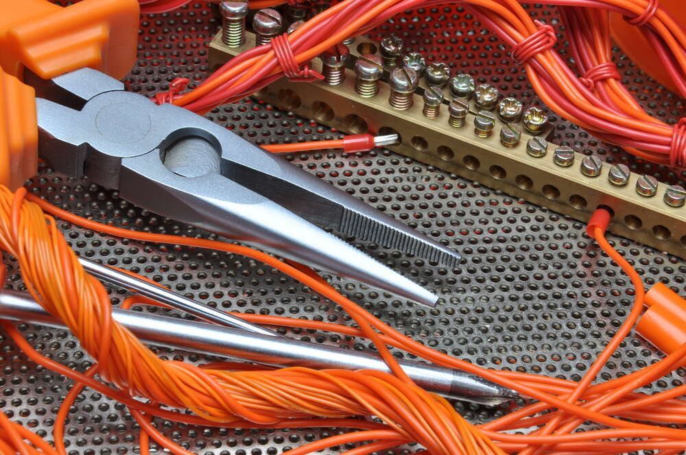 Pair of Pliers Sitting on Top of a Bunch of Wires — Proserpine Electrical Services in Whitsundays, QLD