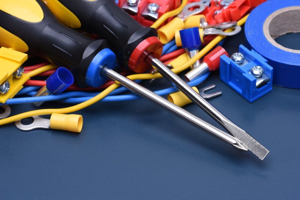 Pair of Screwdrivers Sitting on Top of a Pile of Wires and Tape — Proserpine Electrical Services in Proserpine, QLD
