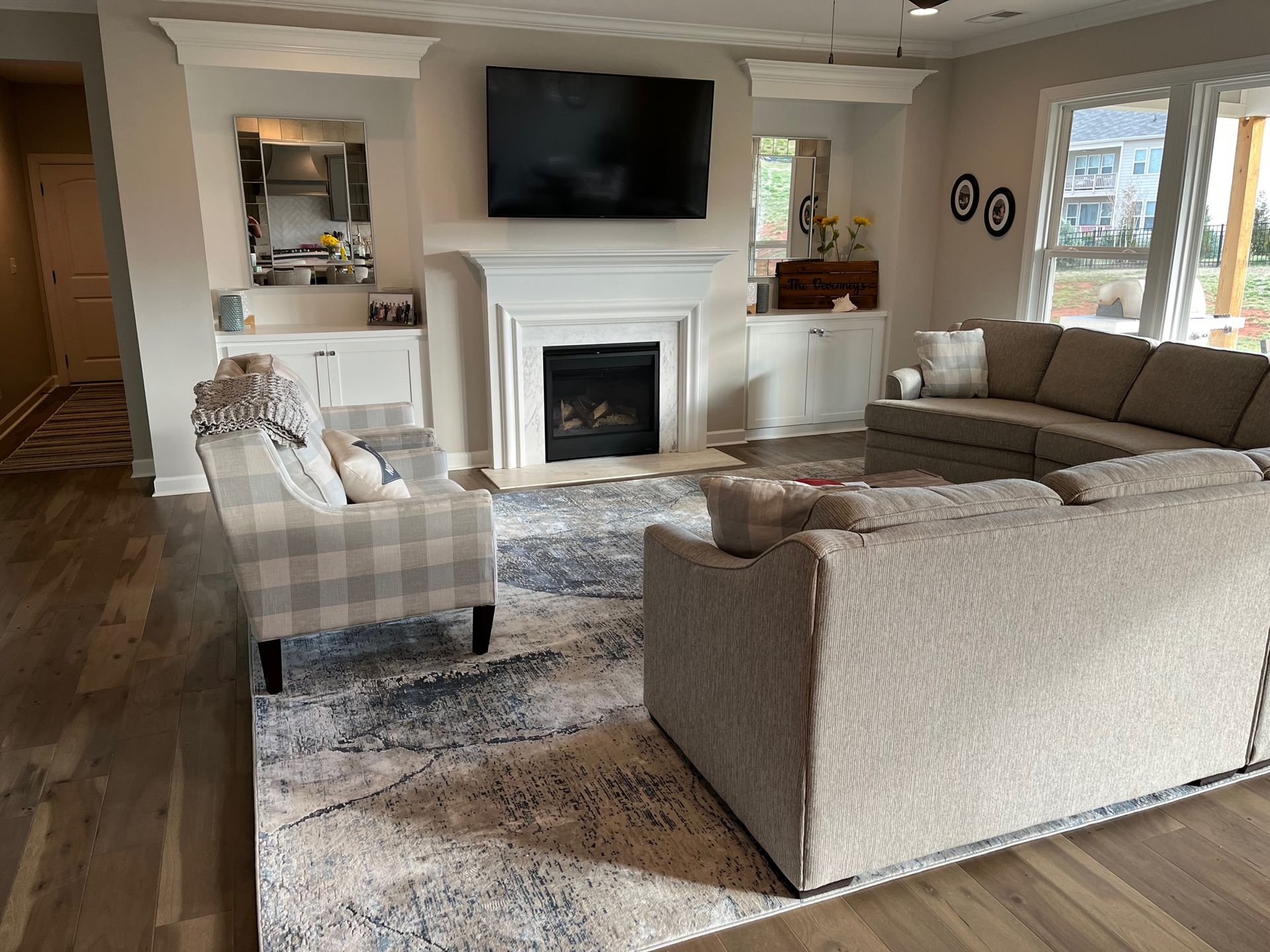 Living room with fireplace, TV, sectional sofa, armchairs, and rug.
