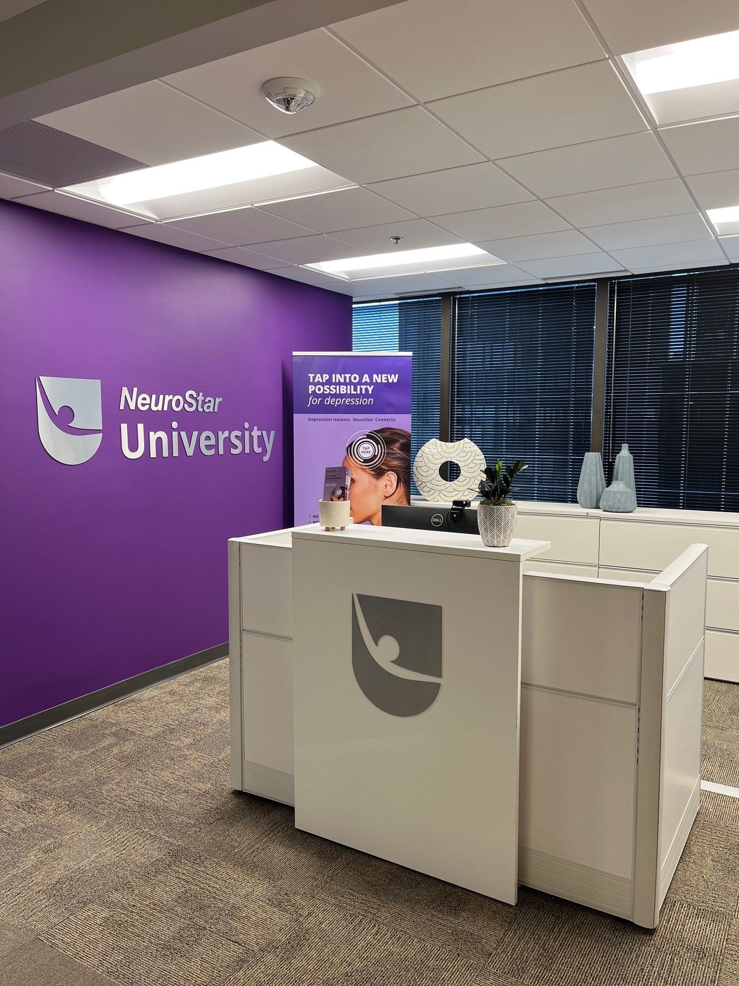 White reception desk in purple-walled office with 
