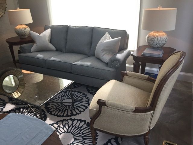 Living room with gray sofa, ivory chair, coffee table, and side tables.