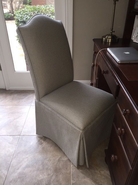 Upholstered dining chair in a patterned gray fabric beside a dark wooden desk with a laptop.