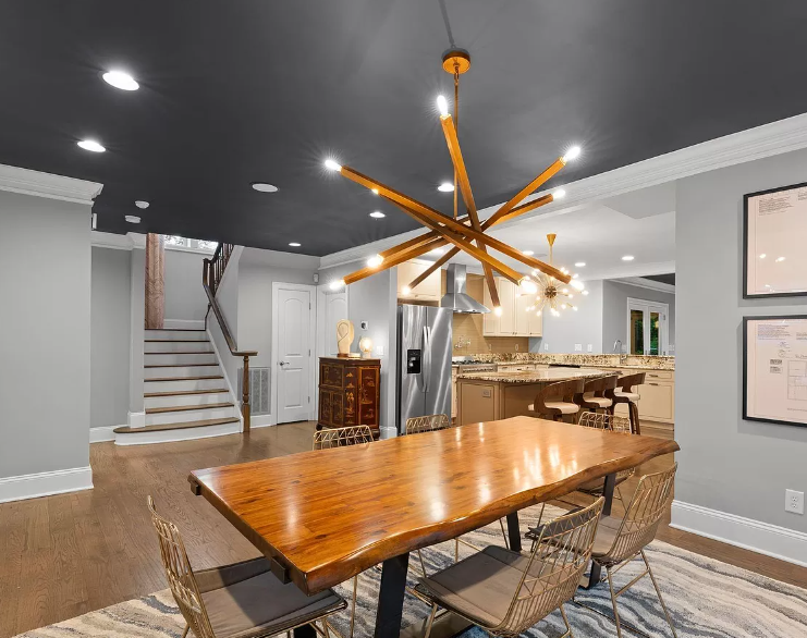 Dining room with wood table, gold chairs, and a unique light fixture.