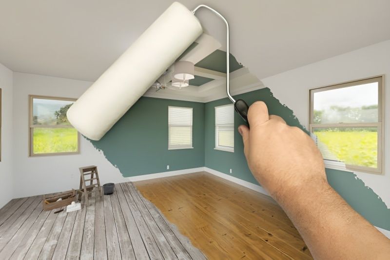 Hand painting room blue with a roller, changing floor from gray to wood.