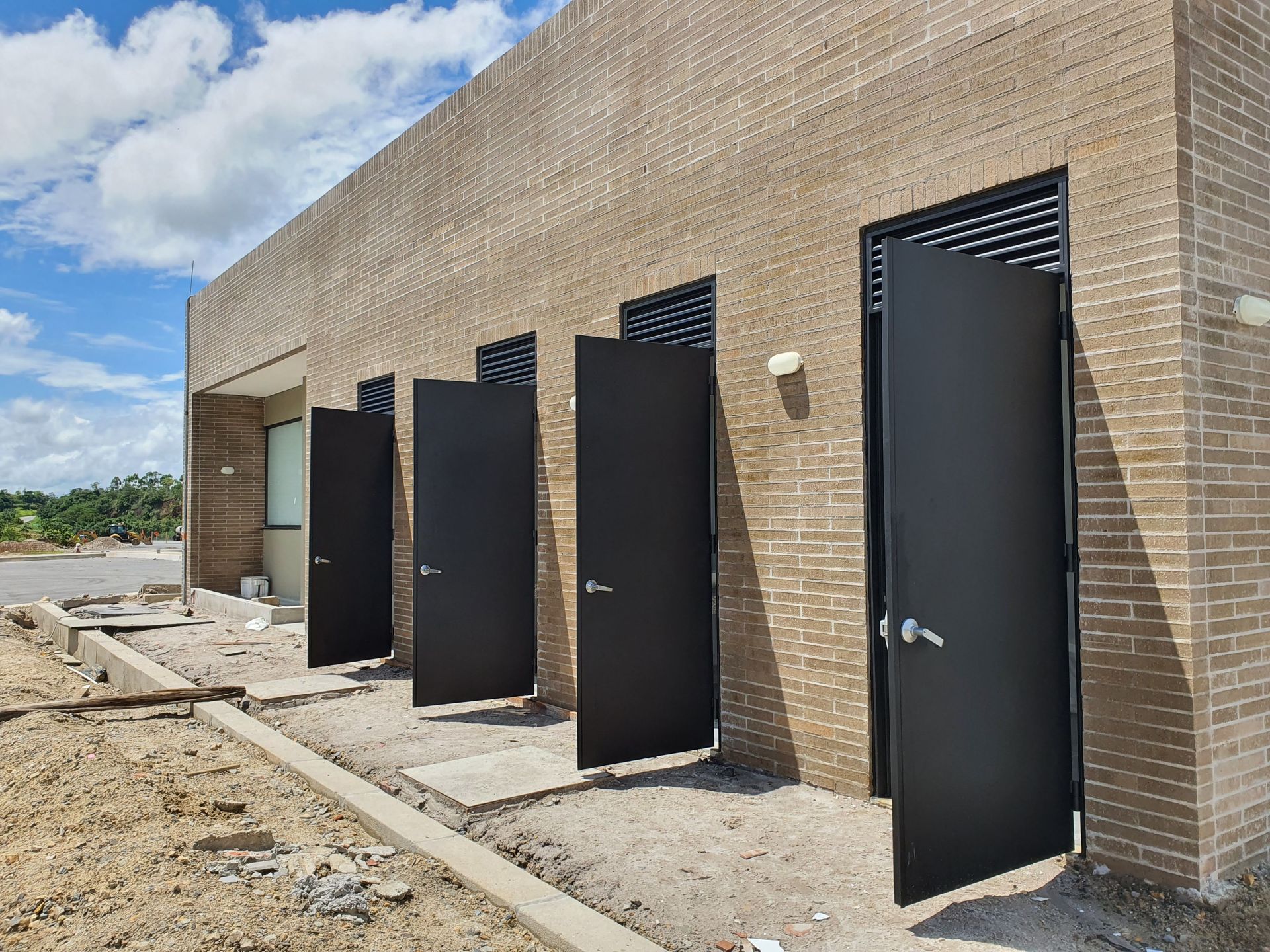 Un edificio con muchas ventanas está al lado de una carretera.