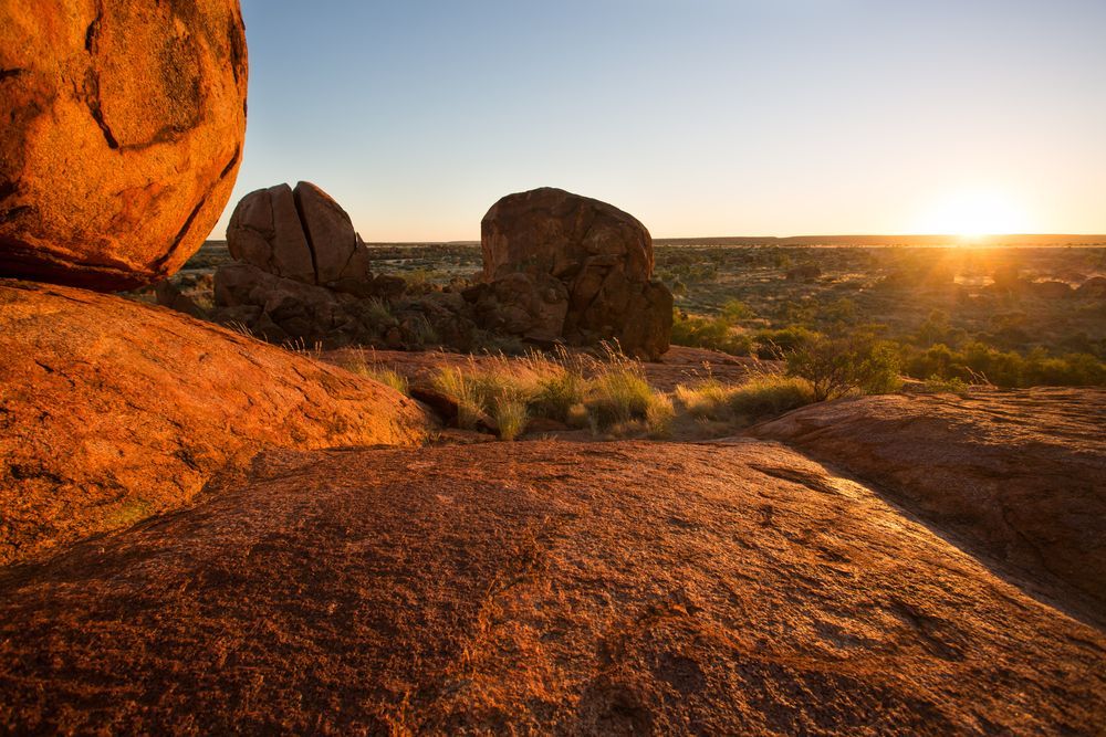 The Sun Is Setting Behind A Large Rock In The Desert — PK Crash Repairs In Tennant Creek, NT