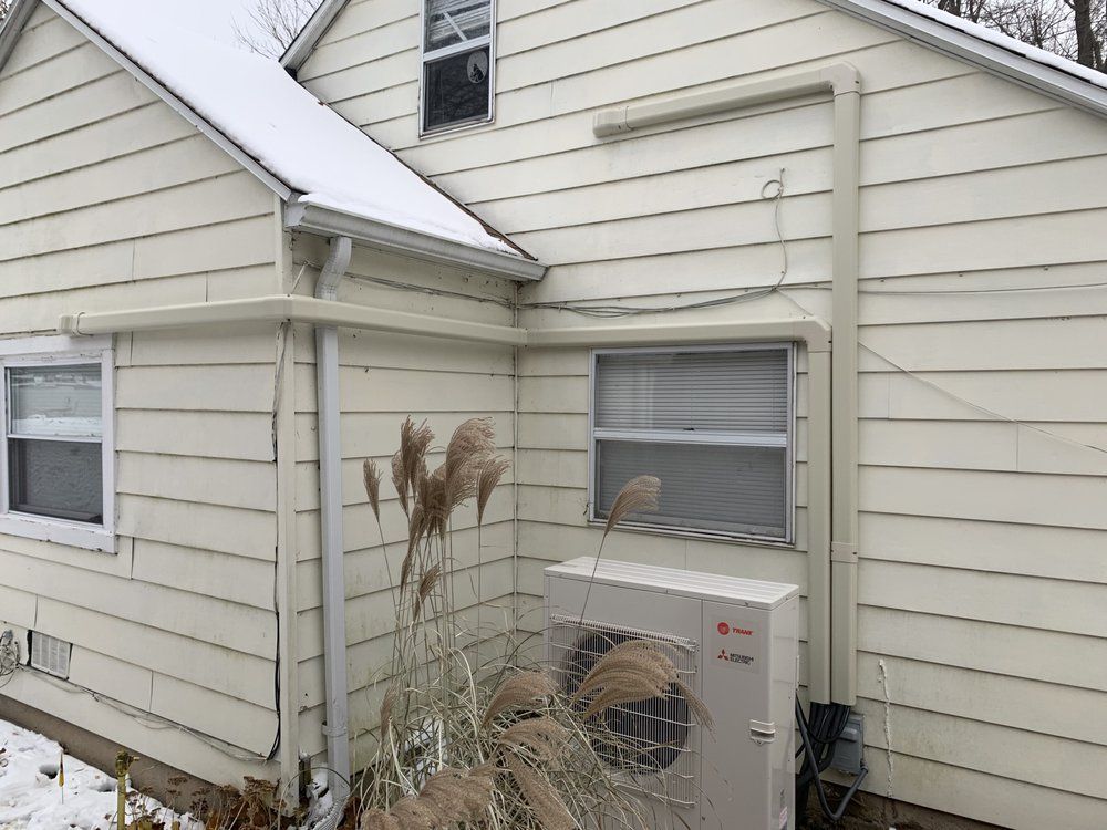 A white house with a large air conditioner on the side of it.