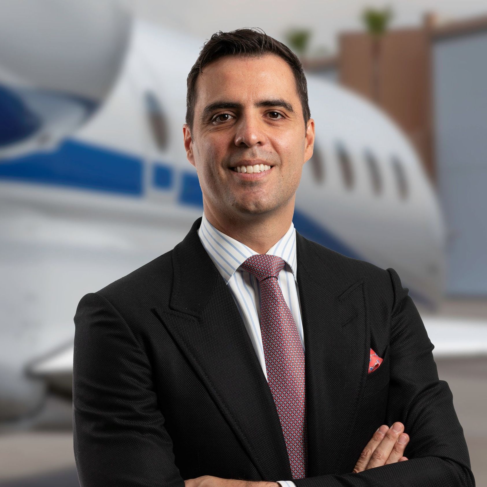 A woman in a suit and blue shirt is smiling for the camera