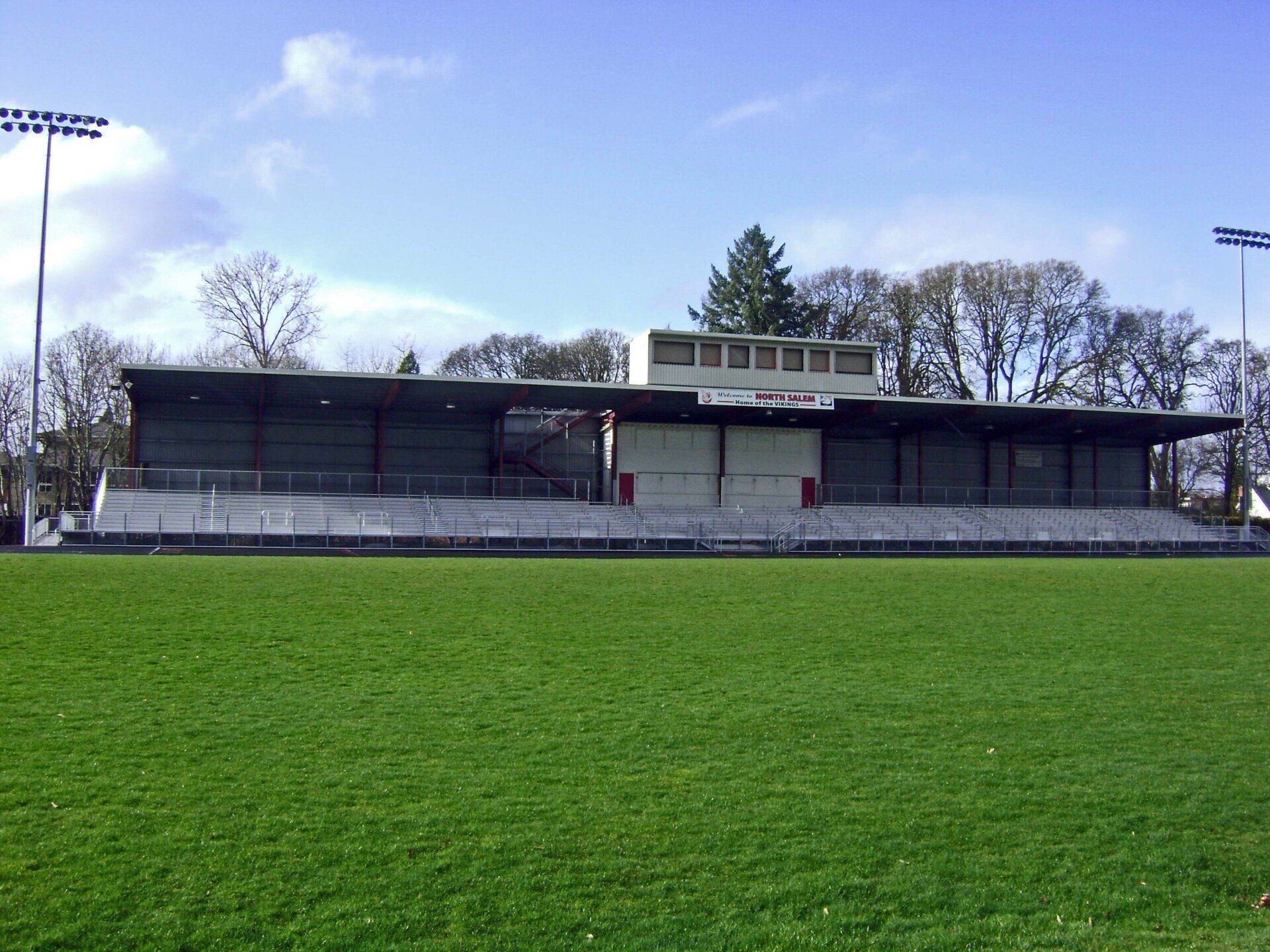 Grass field with a concrete stadium.