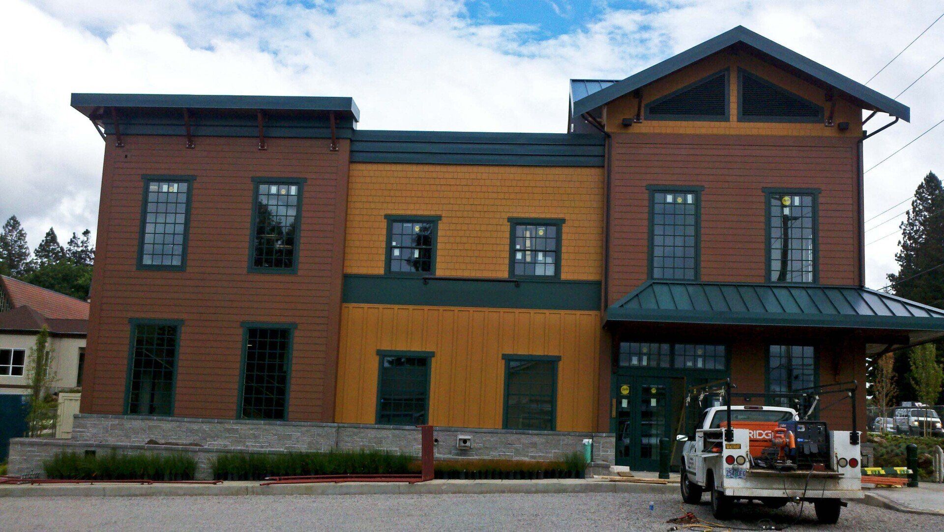 Multi-colored building with green trim, windows, and a truck parked outside.