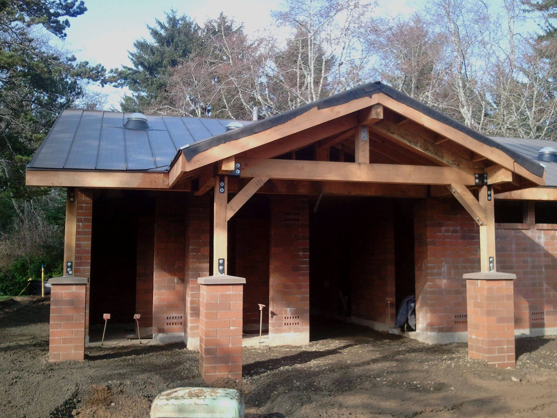 Brick building with wooden entryway; dark roof.