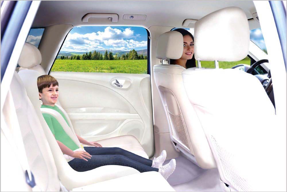 A family is sitting in the back seat of a car.