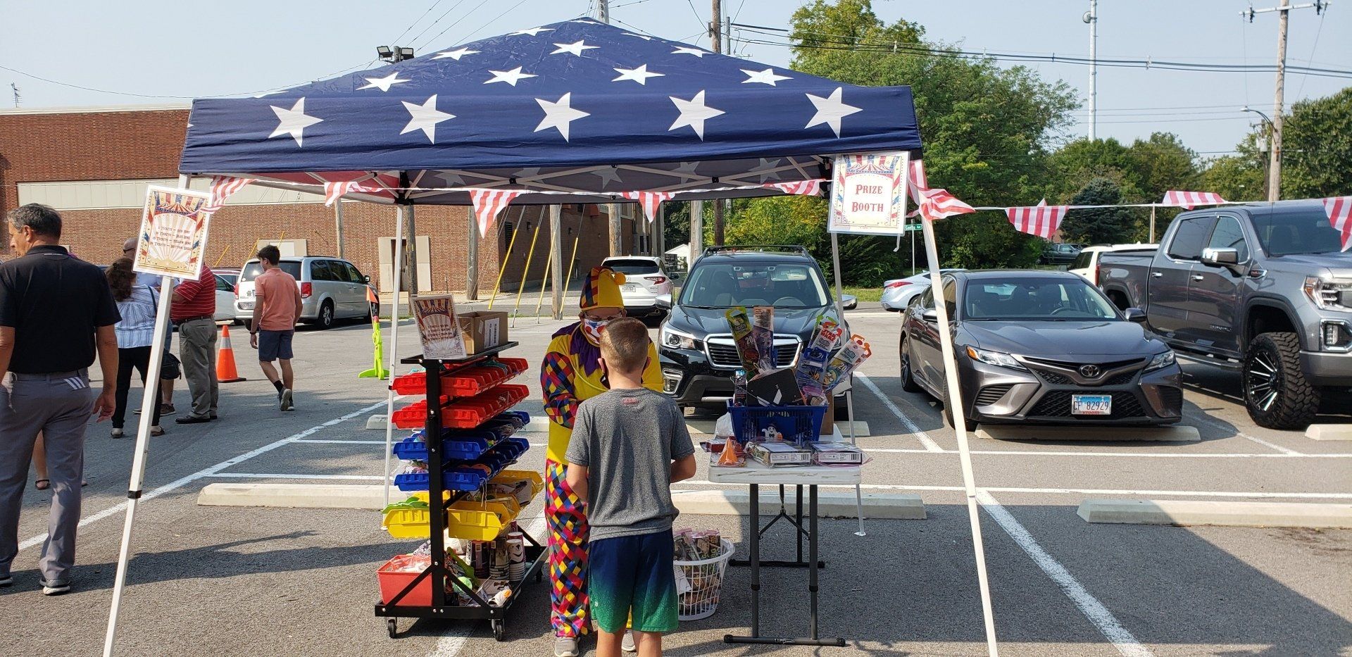 Outdoor market stall under a star-spangled canopy with snacks and a child standing at the table